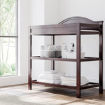 graco story espresso changing table with changing essentials on both shelves in nursery
