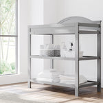 graco story pebble gray changing table with changing essentials on both shelves in nursery