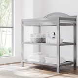 graco story pebble gray changing table with changing essentials on both shelves in nursery