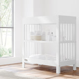 teddi white changing table in nursery with changing essentials on both shelves