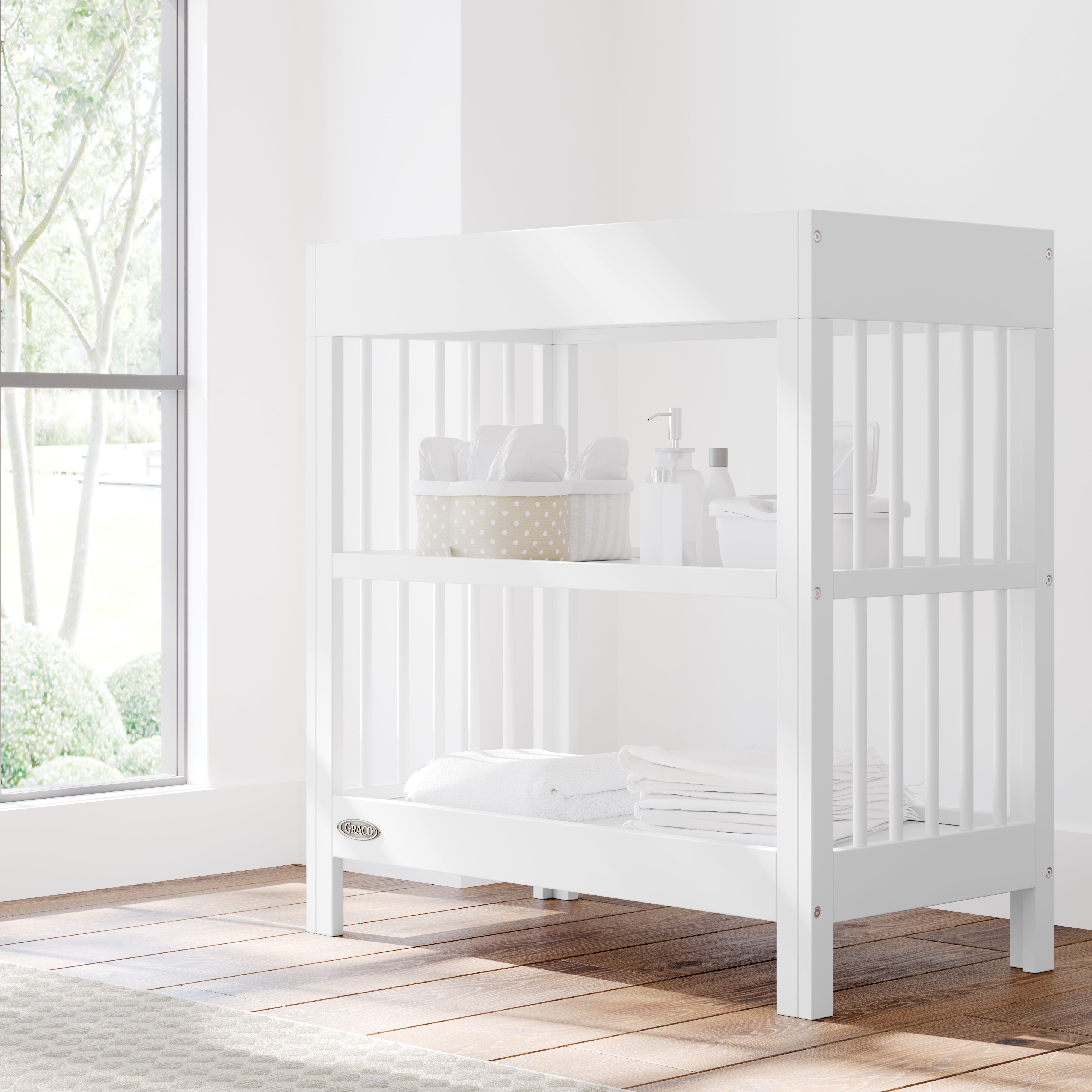 teddi white changing table in nursery with changing essentials on both shelves