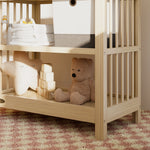 Close-up view of a driftwood changing table in the left corner.