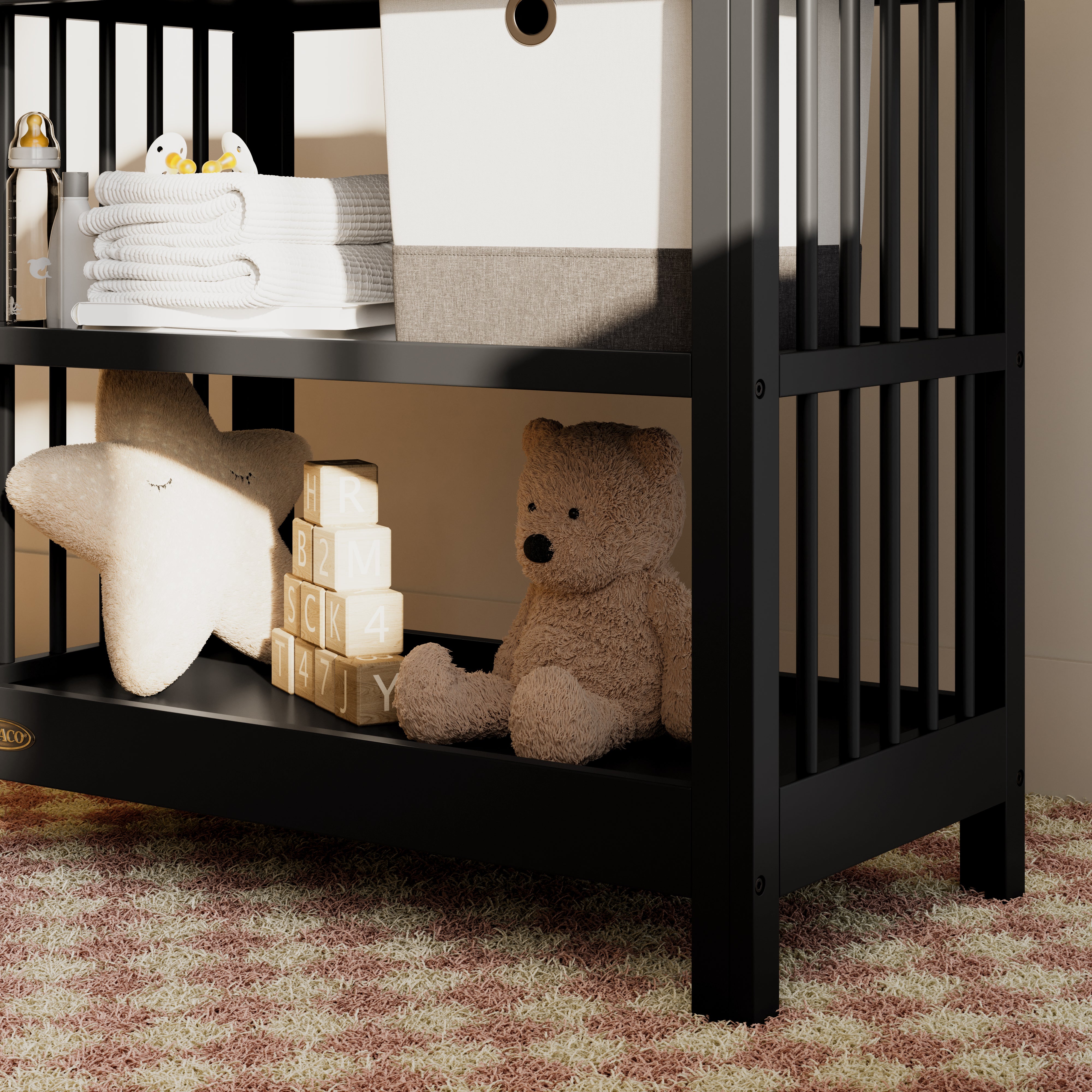 Close-up view of a black changing table in the left corner