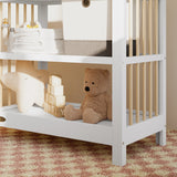 Close-up view of a white with driftwood changing table in the left corner.
