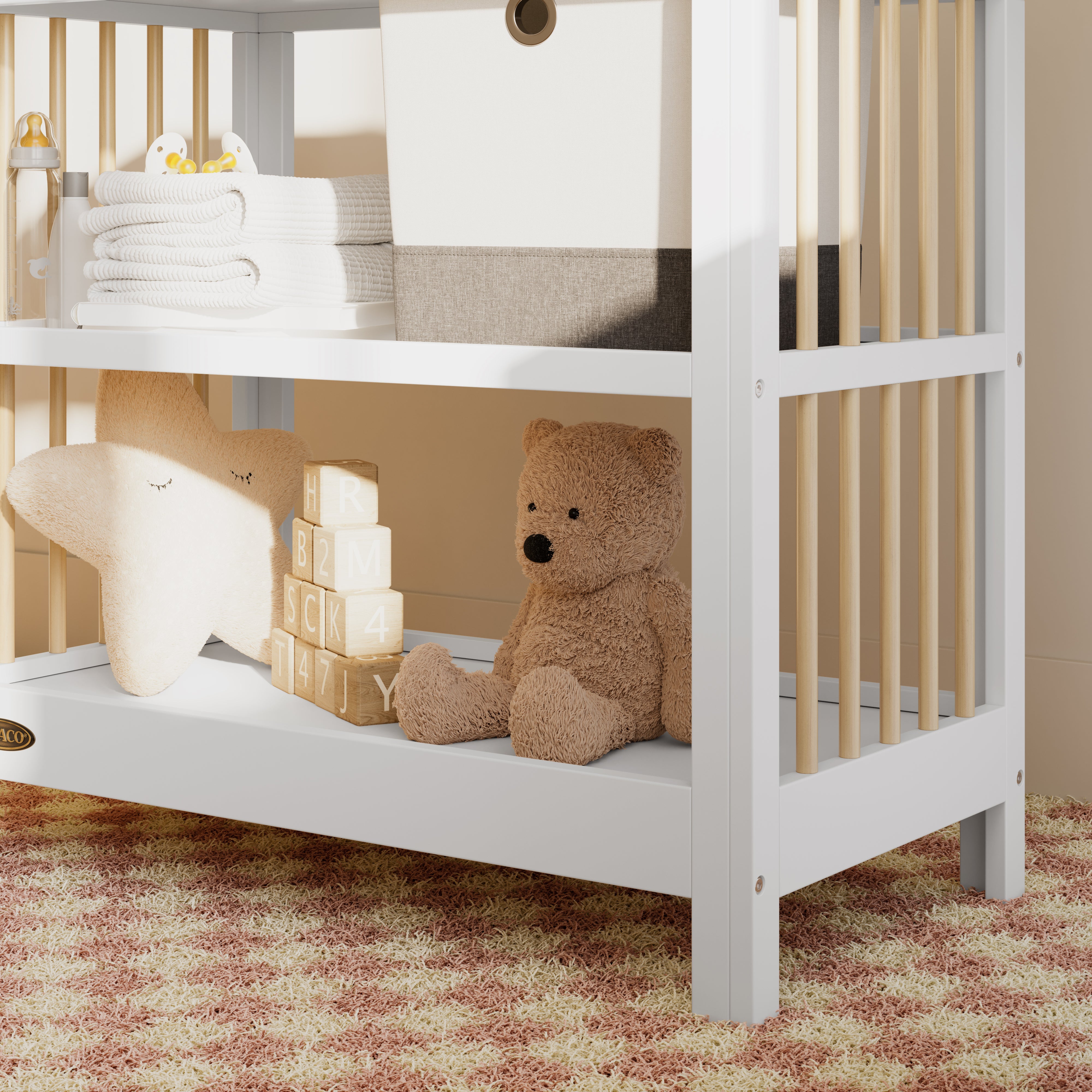 Close-up view of a white with driftwood changing table in the left corner.