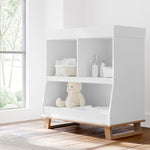 modern convertible white with vintage driftwood changing table in nursery with changing essentials in shelves