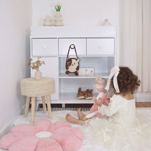Girl in a room with toys in front of a changing table in white finish