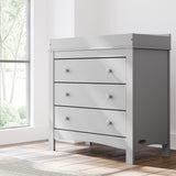 noah 3 drawer chest with topper in pebble gray finish in nursery by window