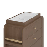 Close up view of Read-with-Me 3 drawer chest's changing topper in hazelnut with driftwood with changing pad