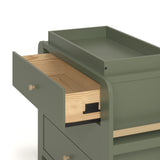 Close up drawer view of Read-with-Me 3 drawer chest with bookshelves and changing topper in olive with driftwood with top drawer open showing interlocking drawer mechanism