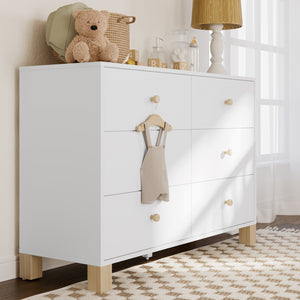 Angled view of white dresser with driftwood knobs and base in nursery  setting