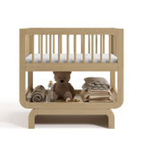 Santorini driftwood bassinet front view with baby items on bottom