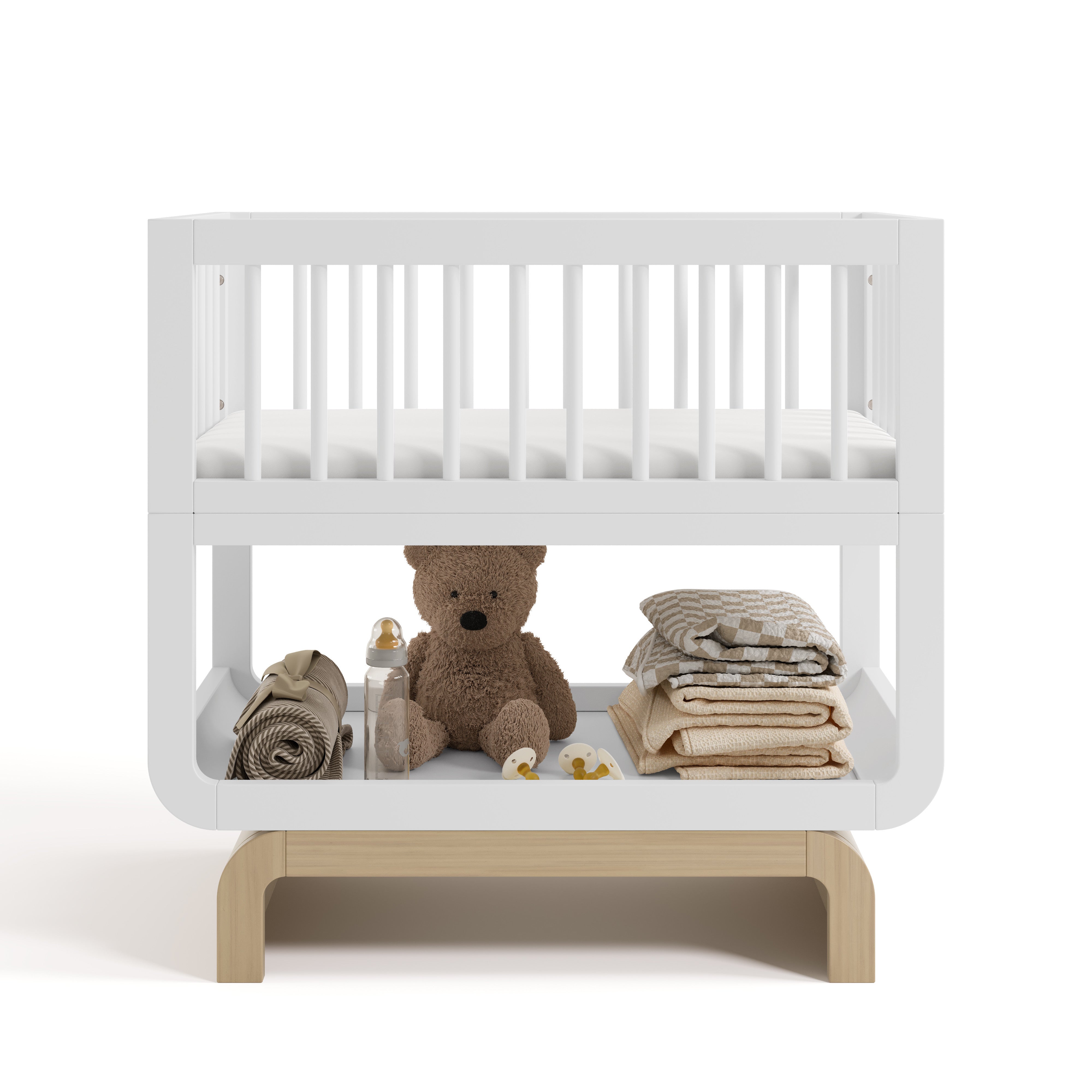 Santorini white with driftwood bassinet front view with baby items on bottom