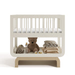 Santorini frosted oat with driftwood bassinet front view with baby items on bottom