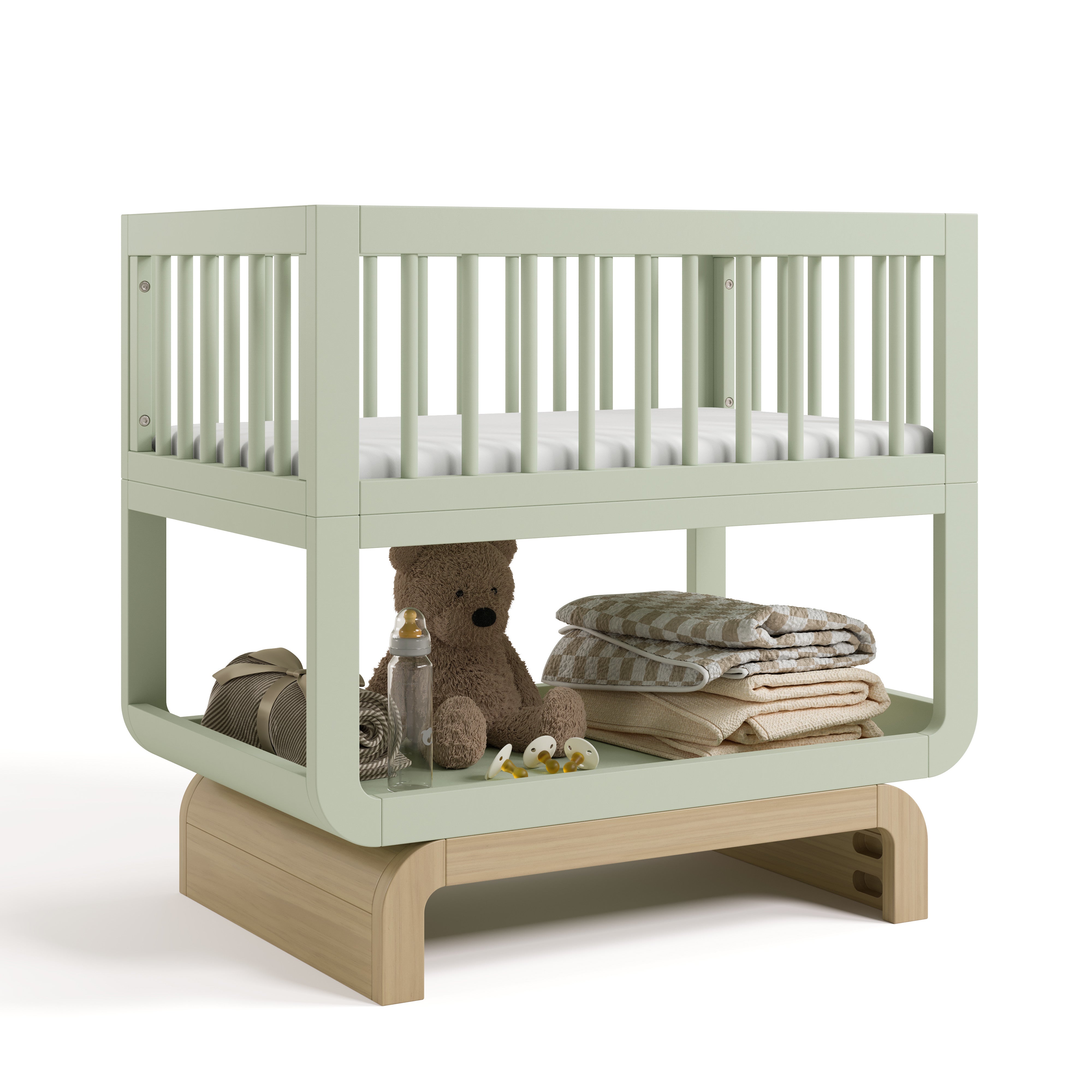 Santorini sage with driftwood bassinet angle view with baby items on bottom