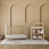 Olivia driftwood changing table in a nursery next to crib