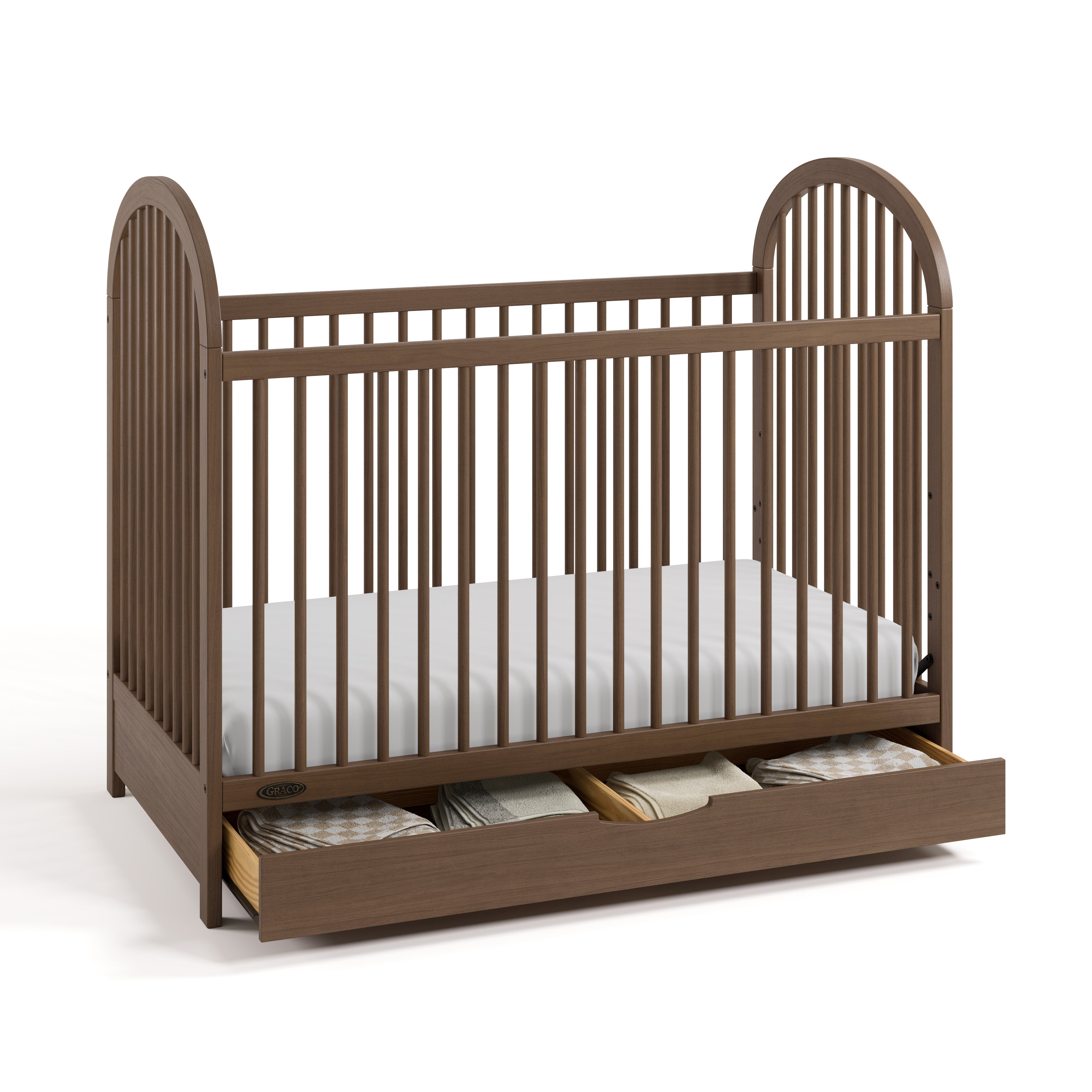 Olivia hazelnut crib with drawer open and bedding inside angle view