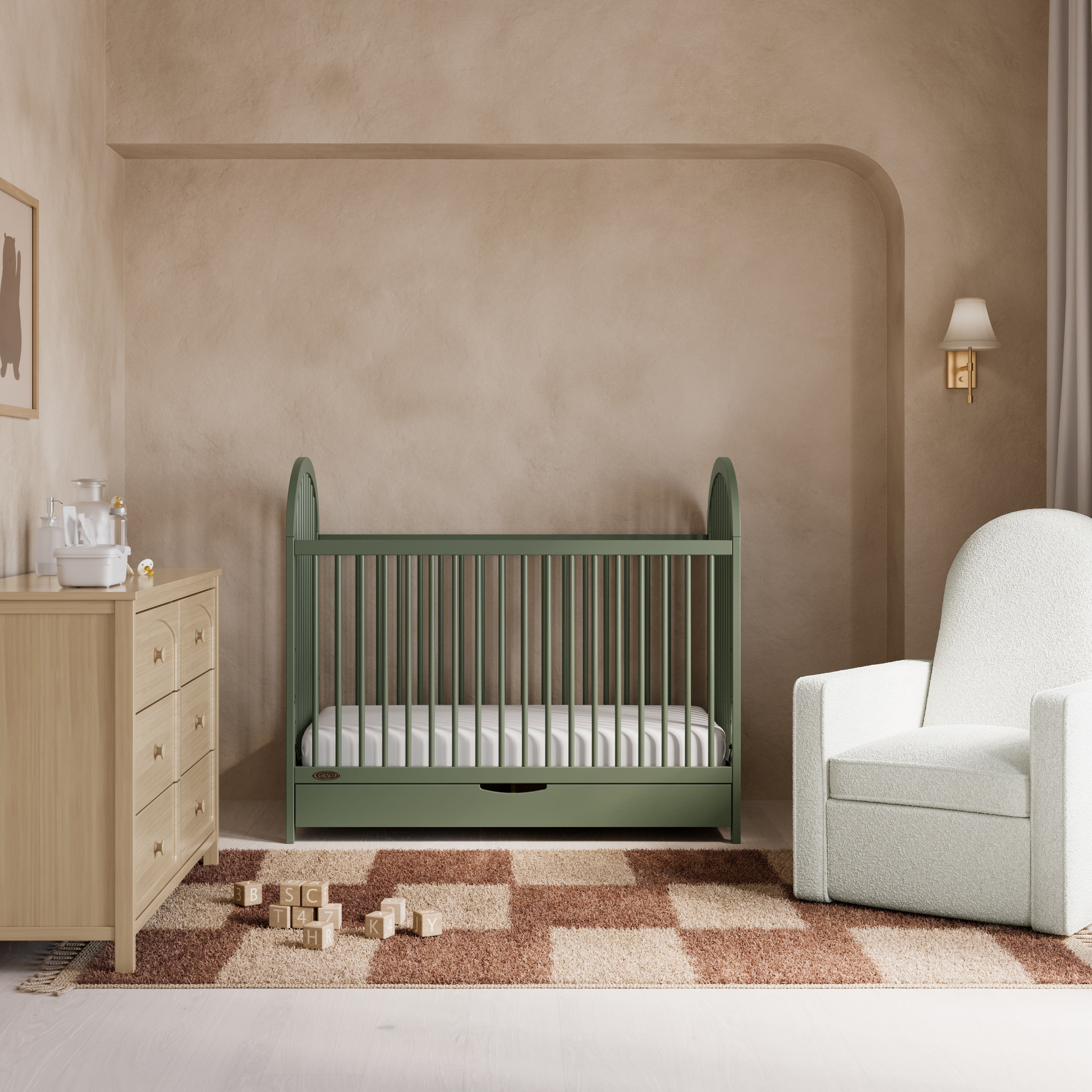 Olivia olive crib with drawer in a nursery