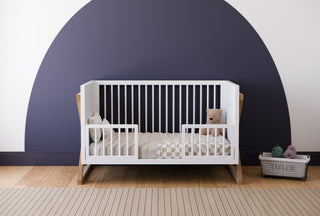 white and vintage driftwood crib toddler bed conversion with two guardrail in nursery