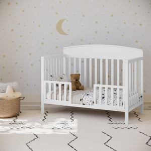 white crib in toddler bed conversion with 2 toddler safety guardrails, in nursery