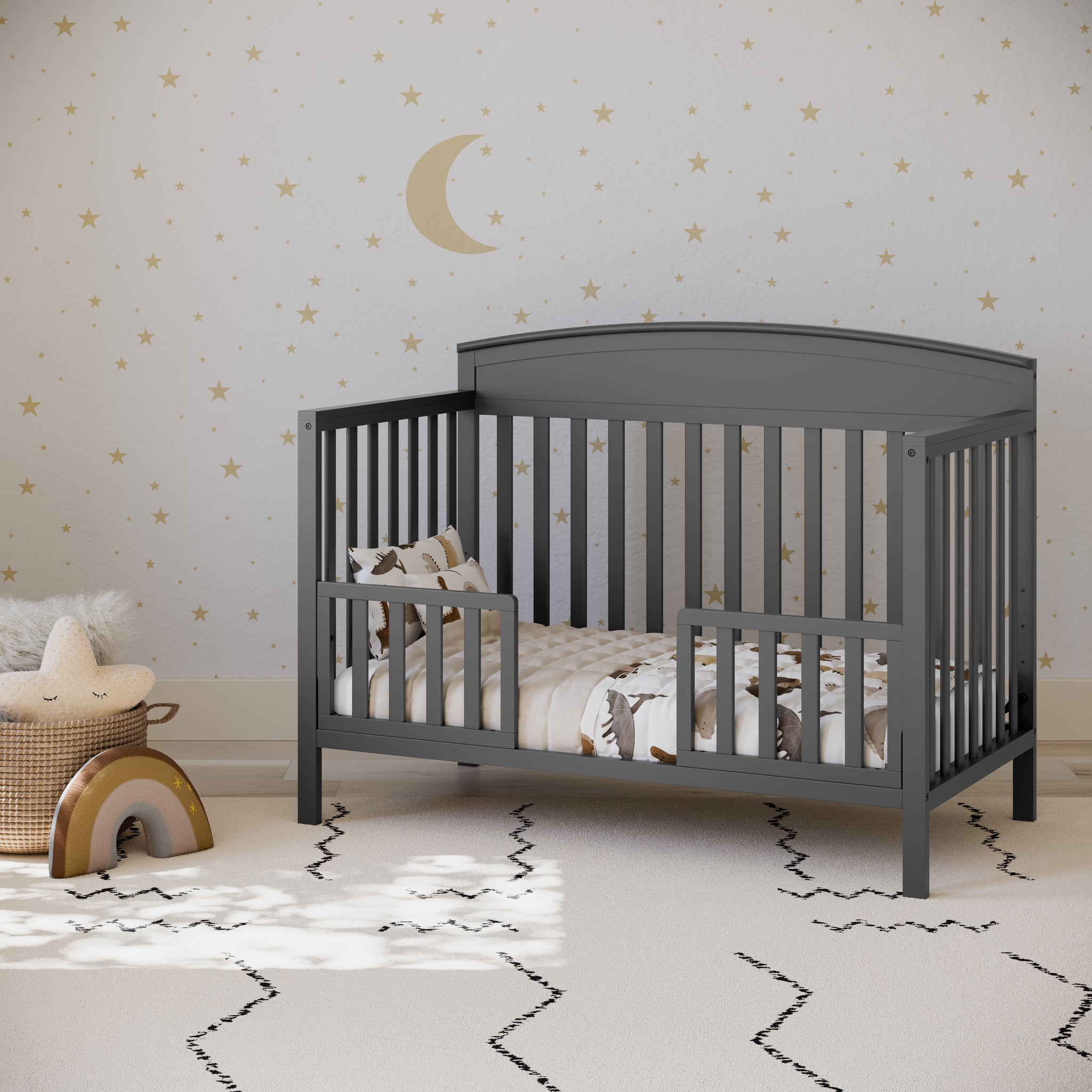 gray crib in toddler bed conversion with 2 toddler safety guardrails, in nursery