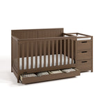 Hadley hazelnut crib and changer with drawer open and baby items inside angle view