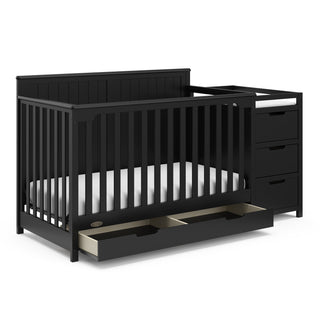 black crib and changer angled with open drawer