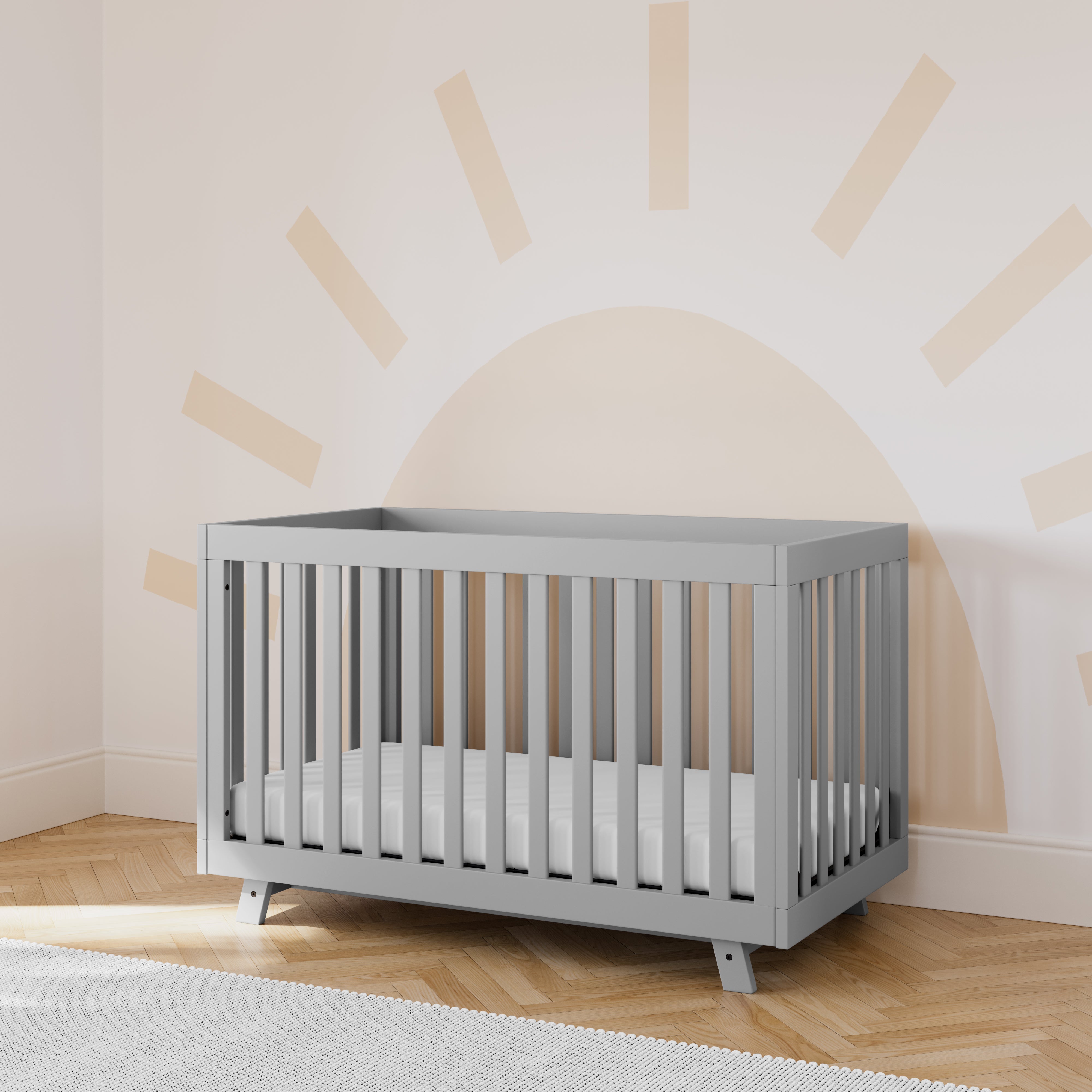 storkcraft beckett pebble gray crib in nursery with sun wallpaper in back