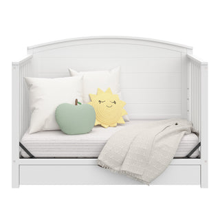 Convertible white crib transformed into a daybed 