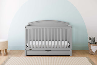 Convertible pebble gray crib in a nursery