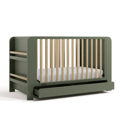 Two-tone olive and natural wood baby crib with an open drawer and bookshelf sides
