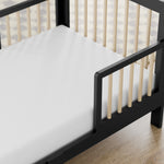 storkcraft pasadena blackwith driftwood toddler bed closeup of guardrail and headboard on wood floor
