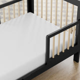 storkcraft pasadena blackwith driftwood toddler bed closeup of guardrail and headboard on wood floor