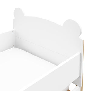 close up view of white with driftwood toddler bed