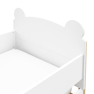 close up view of white with driftwood toddler bed