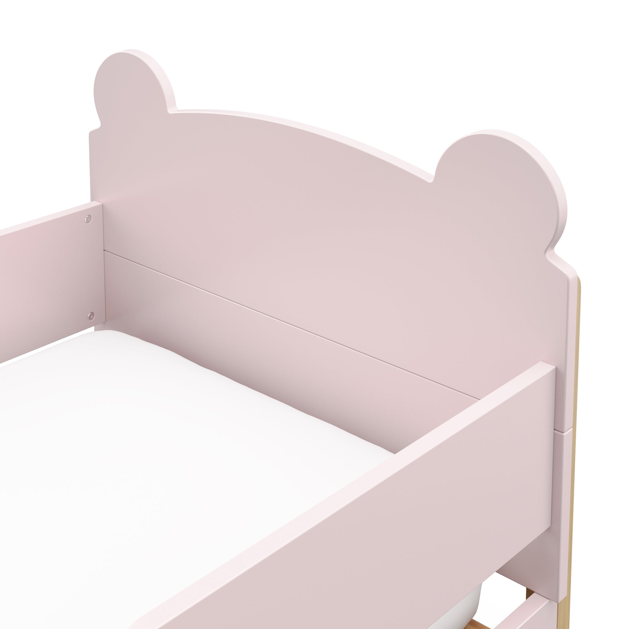close up view of a blush-colored toddler bed