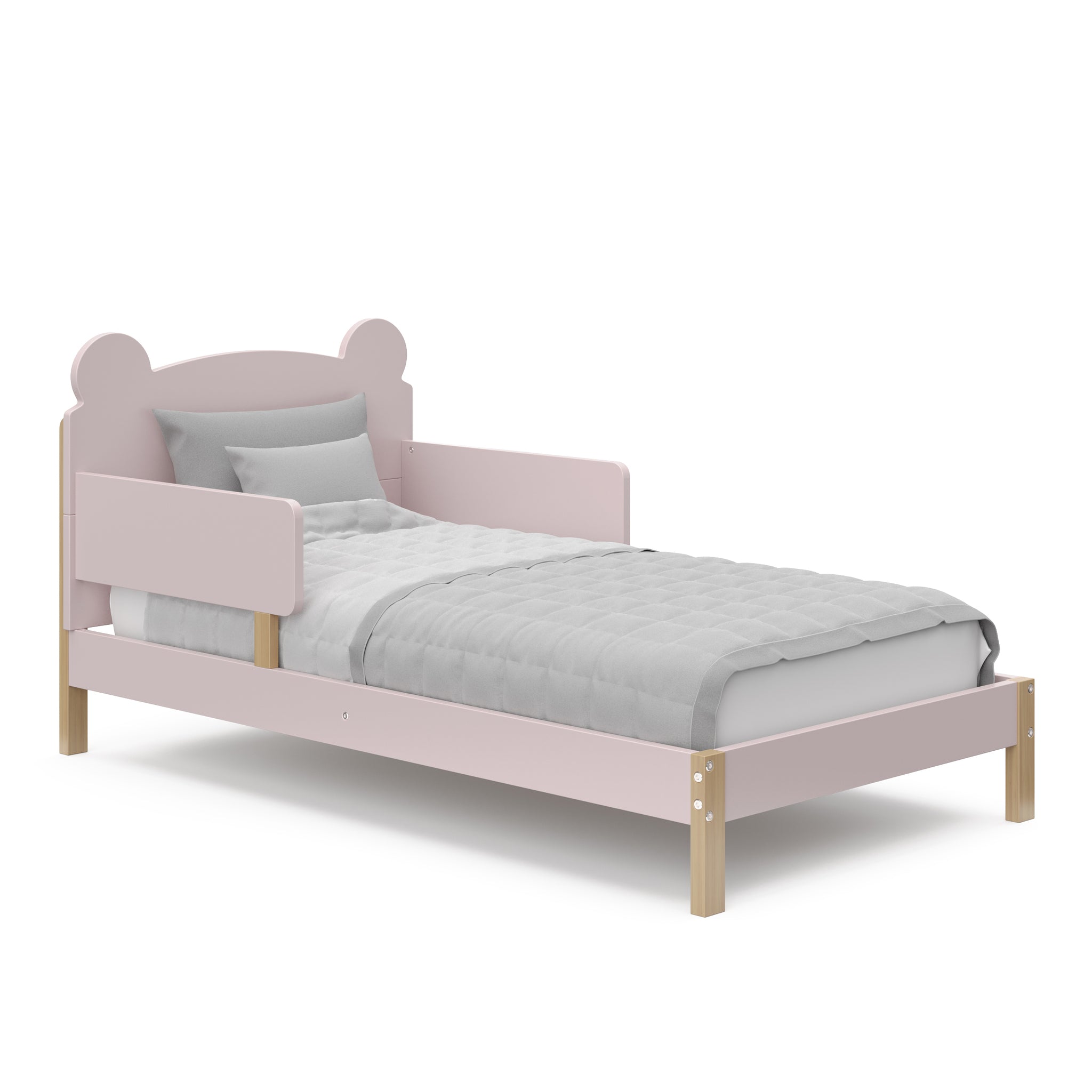 Angled view of a blush-colored toddler bed