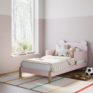 Blush-colored toddler bed in nursery