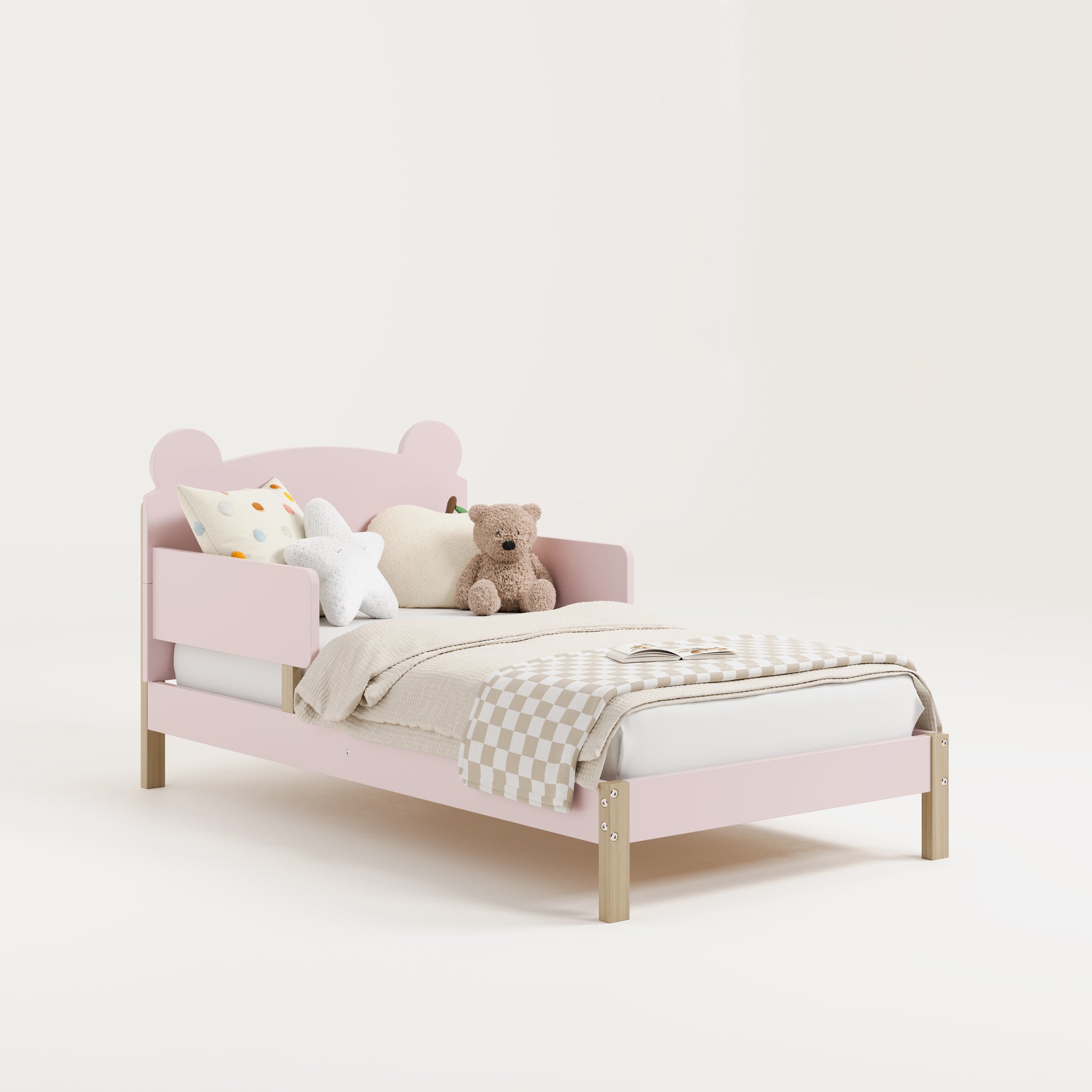 Angled view of a blush-colored toddler bed