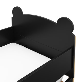 Close-up view of a black-colored toddler bed 