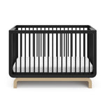 Two-tone black and natural wood baby crib, at a front-facing angle