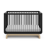 Two-tone black and natural wood baby crib, at a front-facing angle