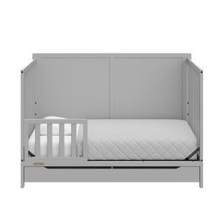 pebble gray crib with drawer in toddler bed conversion with one toddler safety guardrail