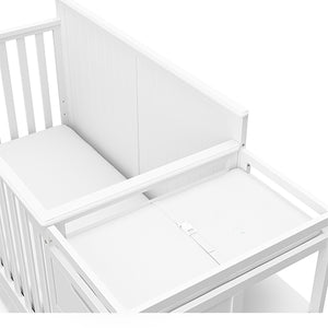 Close-up view of White crib and changer with drawer