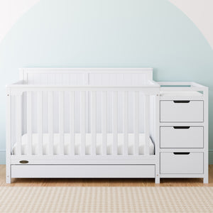 White crib and changer with drawer in nursery