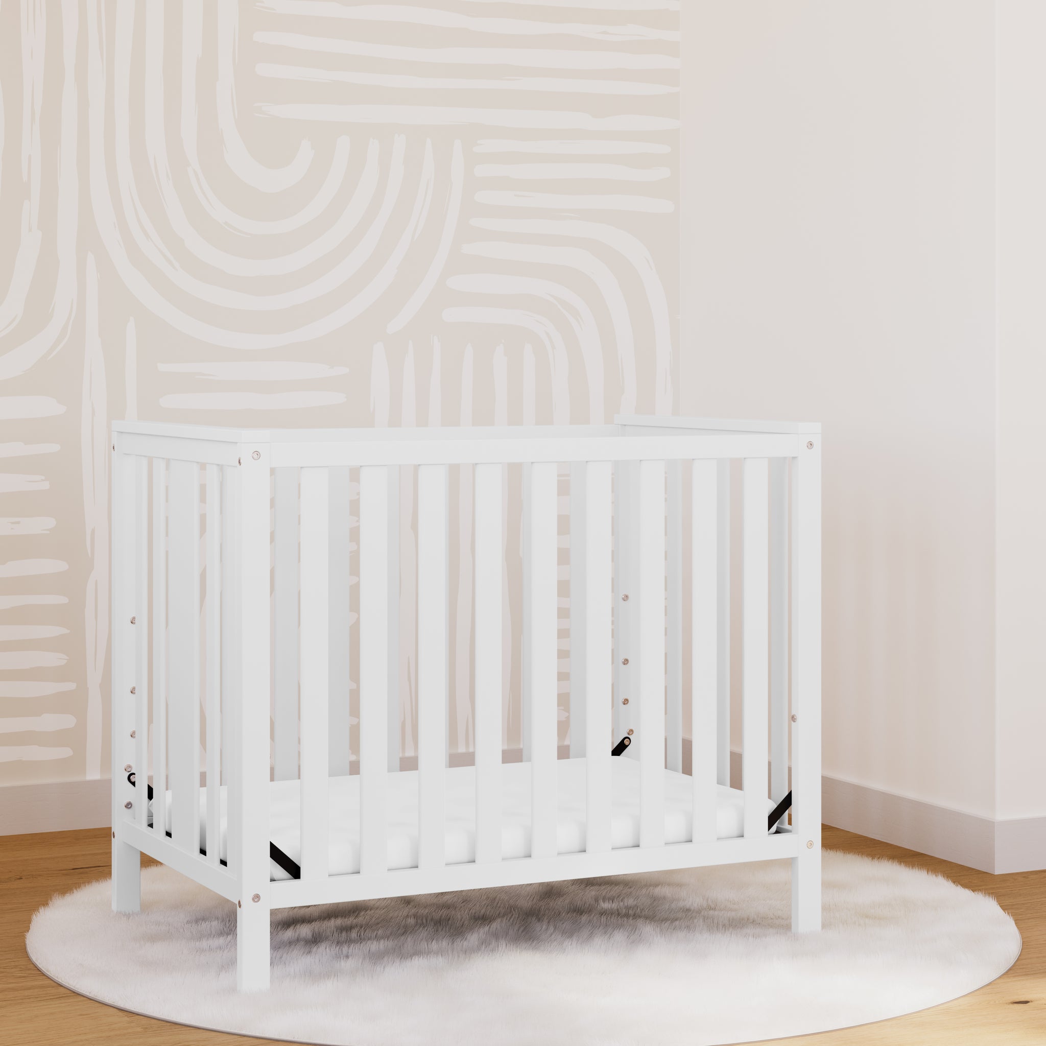 white mini crib in nursery