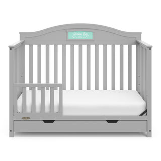 Pebble gray crib with drawer in toddler bed conversion with one safety guardrail