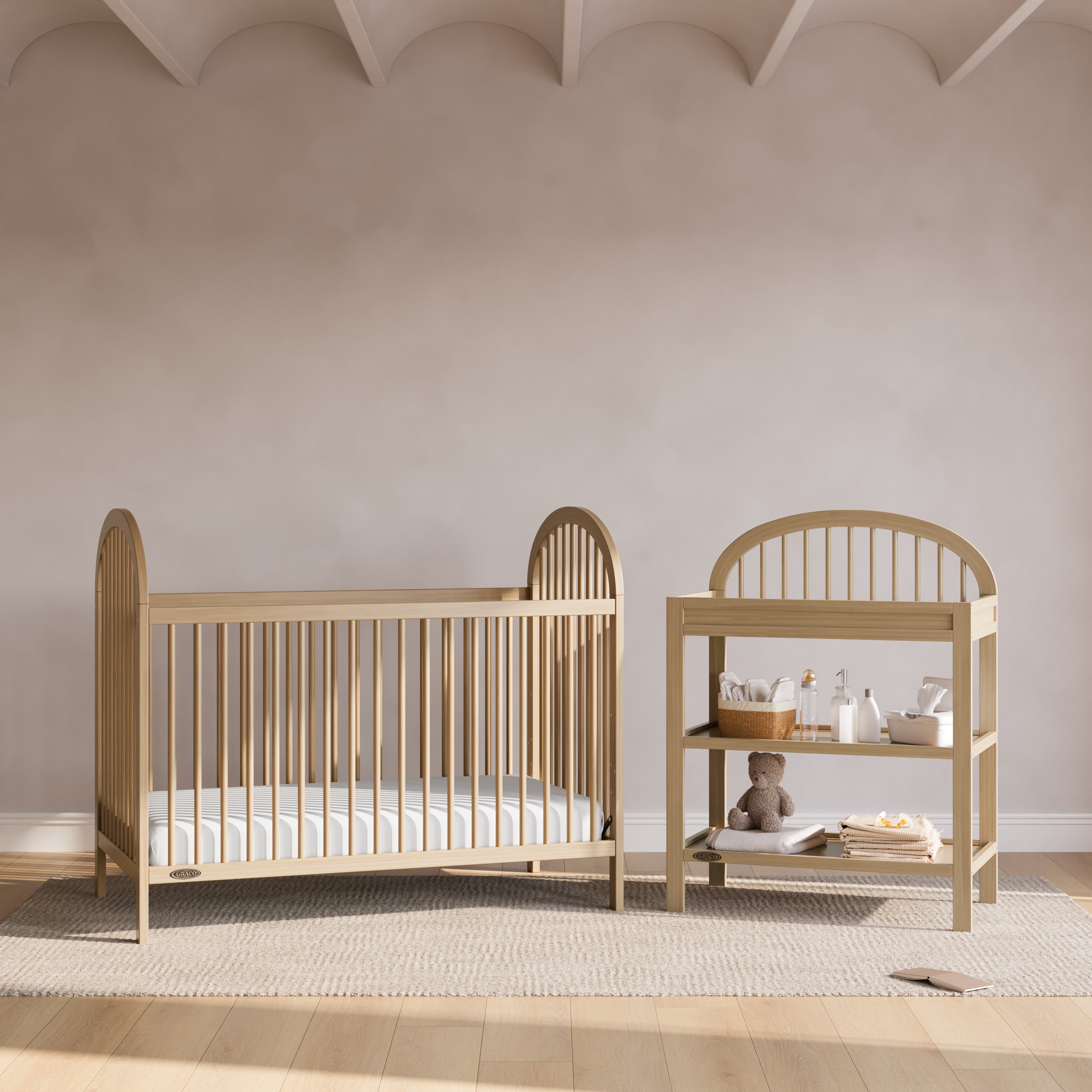 Olivia driftwood changing table next to crib in a nursery