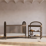 Olivia hazelnut changing table next to crib in a nursery