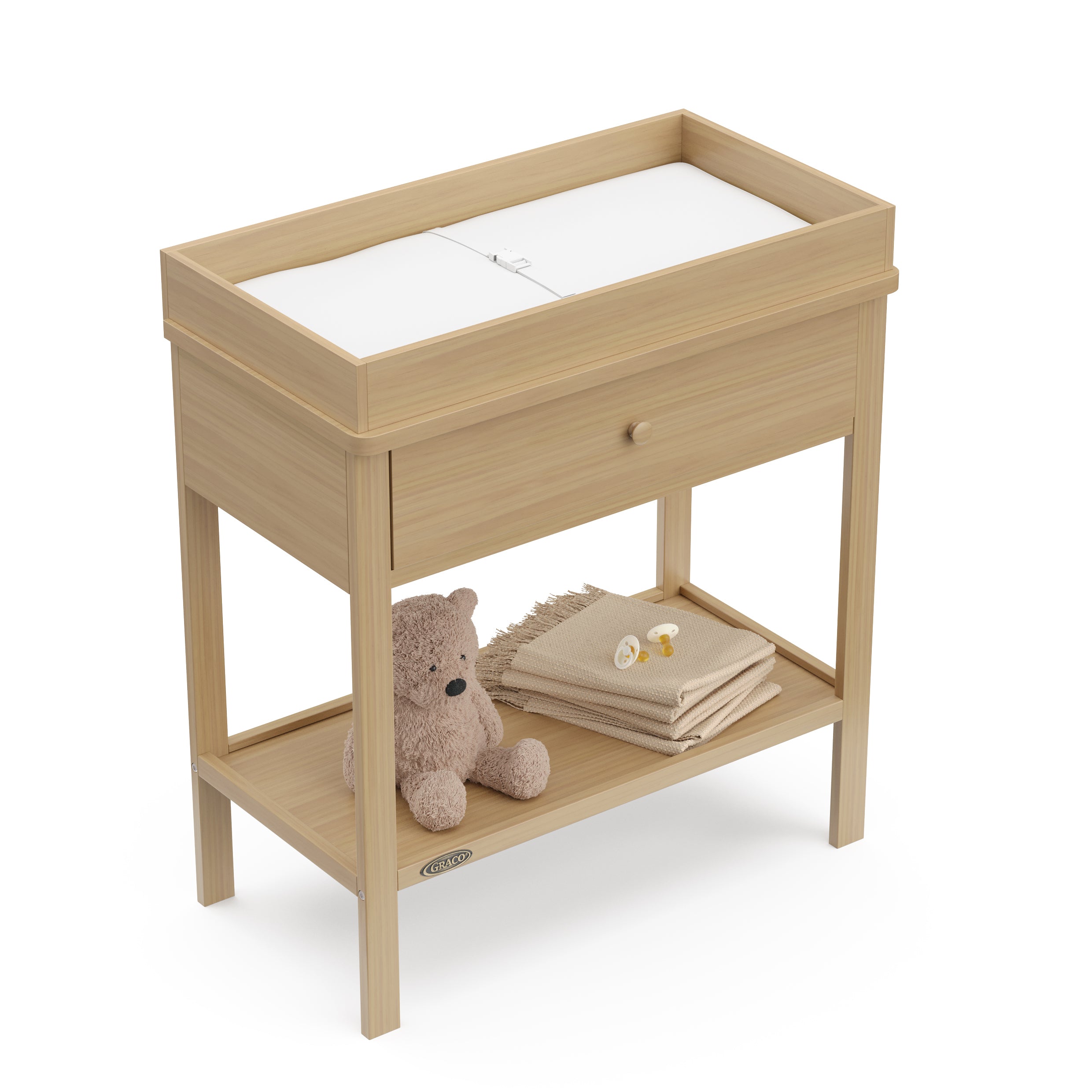 Driftwood Graco storage changing table top view with changing pad and baby items on shelf
